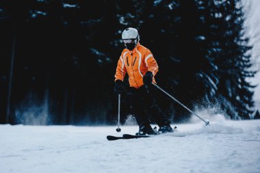 Erkek kayakçı dağlarda bir yamaç. Donmuş karanlık ormanın içinde belgili tanımlık geçmiş. Kayakçı yokuş aşağı Kayak Kış orman dağlarında