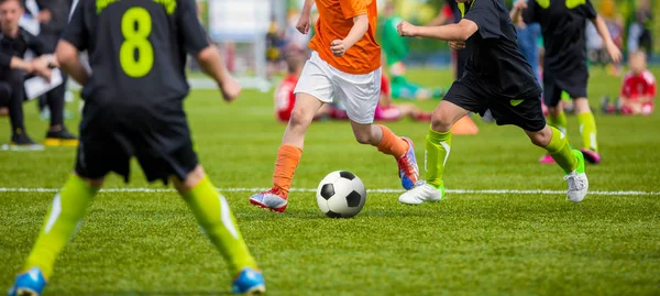 Bambini che giocano a calcio sul campo sportivo. I ragazzi giocano a calcio su erba verde. Competizione di squadre giovanili di calcio. Giocatori di calcio giovanile in esecuzione — Foto Stock