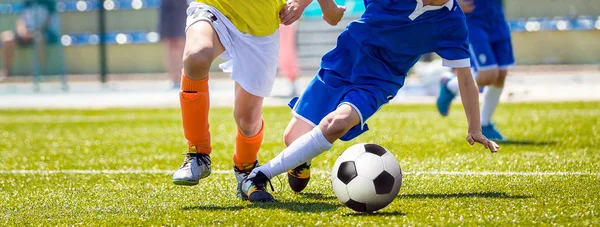 Kör fotboll med unga fotbollspelare. Ungdoms fotboll konkurrens mellan två fotbollsspelare. Fotbollsstadion i bakgrunden — Stockfoto