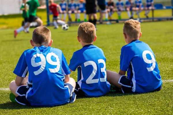 Kinderen voetbalteam kijken naar voetbalwedstrijd — Stockfoto