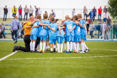 Çocuk futbol futbol takımı koçu ile. Grup birlikte sahada ayakta çocuk. Koç çocuk futbol takım talimatlar verdi. Grup konuşması. Gençlik futbol takımı maçtan önce koçluk
