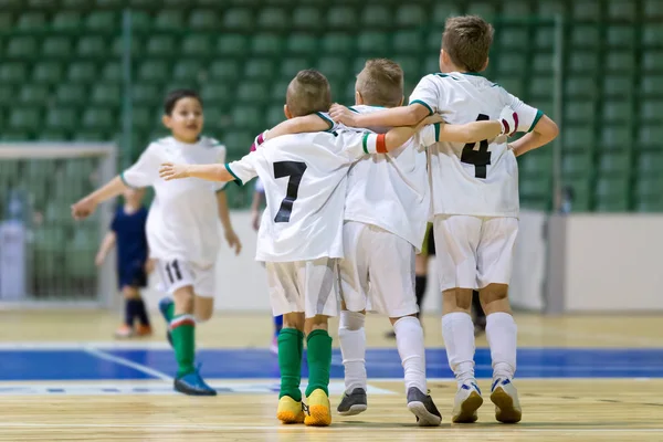 Çocuklar için kapalı futbol futbol maçı. Mutlu çocuklar futsal oyunu kazandıktan sonra birlikte. Chldren spor zafer kutlamak. Gençlik spor zafer