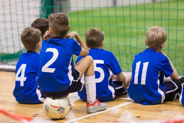 Equipa de futsal infantil. Grupo de jovens jogadores de futebol indoor sentados juntos. Torneio de futebol escolar para crianças — Fotografia de Stock