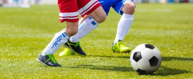 Çalışan ve çim sahada topu tekmeleme futbolcu. Futbol forvet ve Defender rekabet