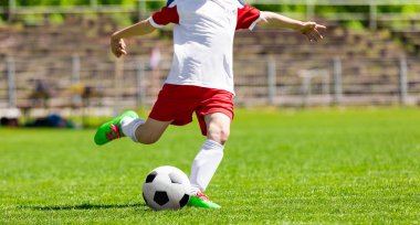 Gençlik futbol futbol oyuncusu bir top Hits. Çim sahada topu tekmeleme futbolcu