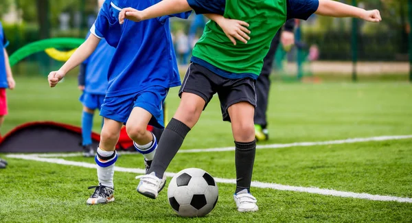 子供たちは遊ぶスポーツです。フットボールを蹴る子供に一致します。緑の芝生ピッチでサッカー少年。青少年スポーツ競争をもたらす。水平サッカーの背景 — ストック写真