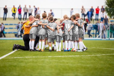 Futbol koçluk. Genç erkek moral turnuva maçtan önce koçla sahip. Çocuklar Futbol Akademisi ekibi sahada. Gençlik futbol koçu koçluk çocuk