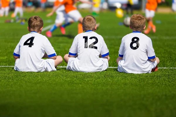 Treinando Futebol Juvenil. Young Boys Sitting on Football Field and Watching Tournament Game (em inglês). Jogo de futebol para crianças — Fotografia de Stock