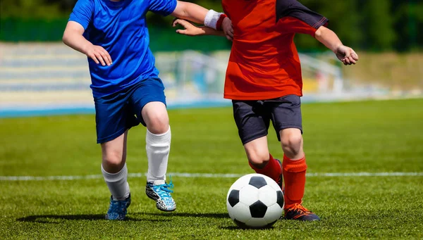 Equipes de crianças jogando futebol jogo de futebol em um campo de esportes — Fotografia de Stock