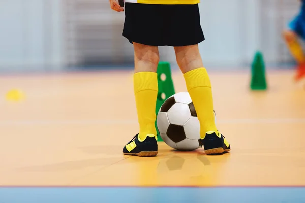 Voetbal futsal training voor kinderen. Indoor voetballer jonge speler met een voetbal in een sporthal. Voetbal training dribbelen kegel boor. Speler in blauw uniform. Sport achtergrond — Stockfoto