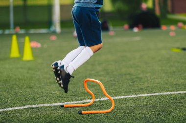 Futbolcu antrenman seansına atlıyor. Futbol Eğitim Ekipmanı. Otlakta Zıplayan Atlet