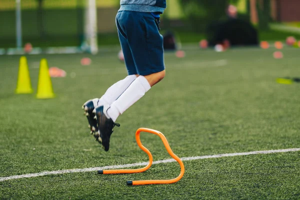 Soccer Player Jumping on Training Session Pitch. Football Training Equipment. Athlete Jumping Over Hurdle on Grass Field — 스톡 사진