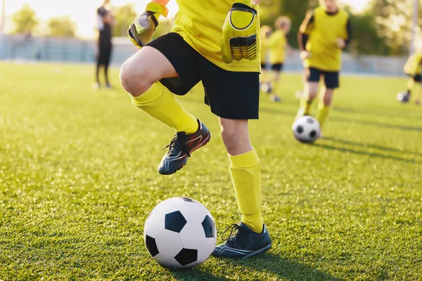 Soccer players on training field on football camp. Kids practice soccer on summer day. Kids participate in sports camp for talented youth soccer player — ストック写真