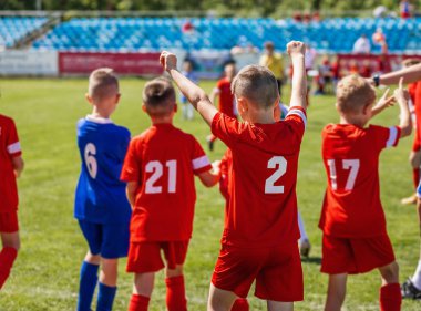Mutlu çocuklar futbol maç kazanan. Genç başarılı futbol futbolcular sahada. Kazanan çocuk Holding eller yukarı