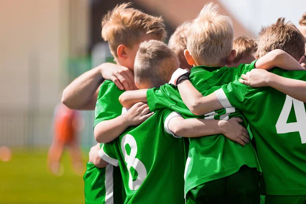 Glückliche Sportjungs in einer Schulmannschaft. Kinder kuscheln sich vor dem Finale in einem Team auf einem Turnier-Wettbewerb. Spieler versammeln sich in einem Kreis, um Strategien zu entwickeln und zu motivieren — Stockfoto