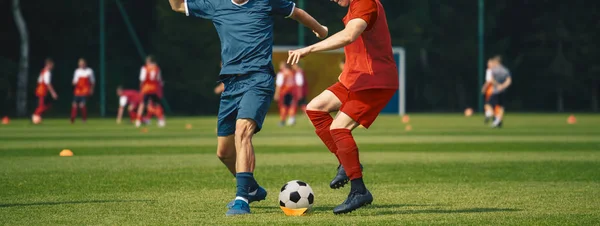 Dois homens a pontapear a bola de futebol. Equipe de futebol adolescente júnior em jogo de treinamento — Fotografia de Stock