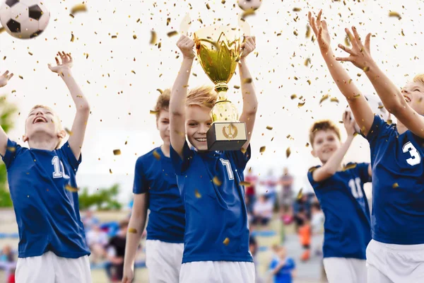 Чемпион молодежной футбольной команды с трофеем. Футбольная команда мальчиков празднует победу — стоковое фото