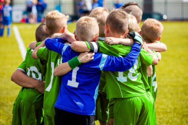 Boys Football Players in School Team on Huddling. Football; soccer; handball; volleyball; match for children. shout team, football soccer game. Team work and unity. Time break with junior coach