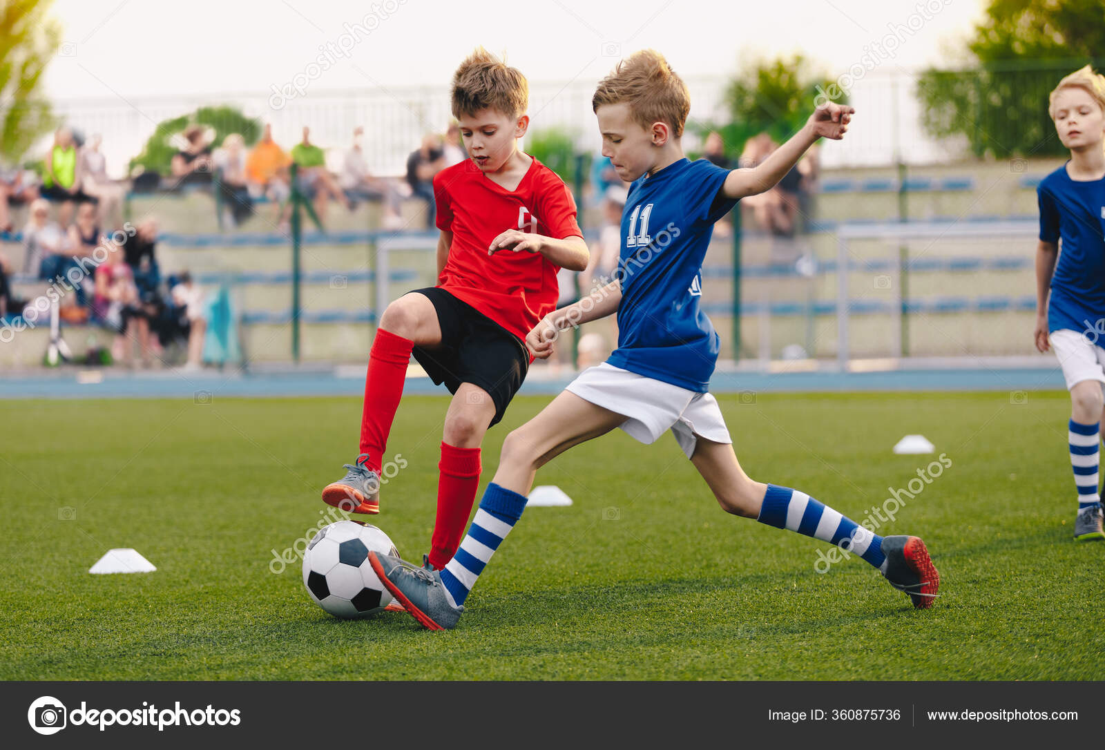 Jogadores de futebol adolescentes chutando bola de futebol campo