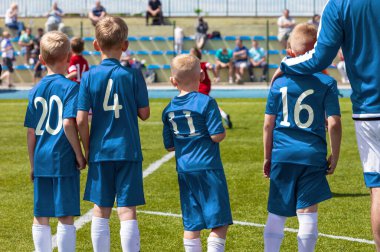 Genç Sporcu Futbolcu Grubu Sideline 'de koçla birlikte. Futbol takımı yedek oyuncuları. Gençlik Futbol Takımı 'nın koçu Oyun oynamaya hazır bir çocuk seçiyor.