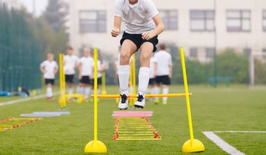 Güneşli bir günde sahada antrenman yapan futbolcular. Fitness Eğitiminde Futbolcu. Hız ve Çeviklik Antrenmanında Genç Futbolcular