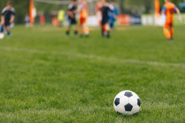 Spor arka planı. Sahada futbol topu. Bulanık arkaplanda futbol turnuvası maçı var. Yaz mevsiminde spor stadyumu