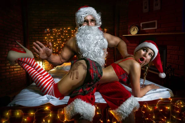 Babbo Natale seduto con ragazza sexy Foto Stock