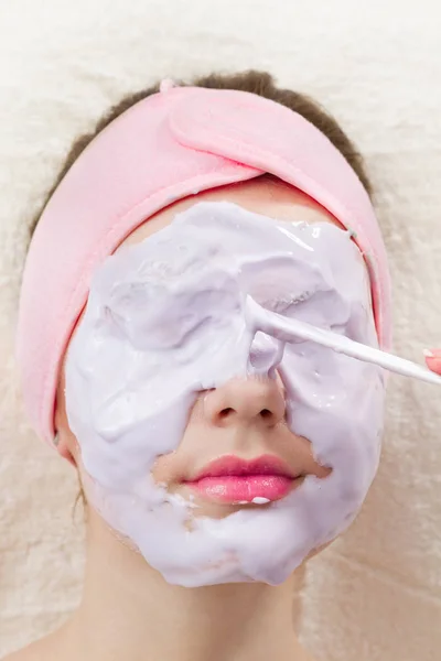 Girl receiving facial mask — Stock Photo, Image