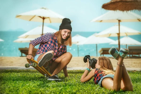 Mujer en monopatín y chica haciendo fotos — Foto de Stock