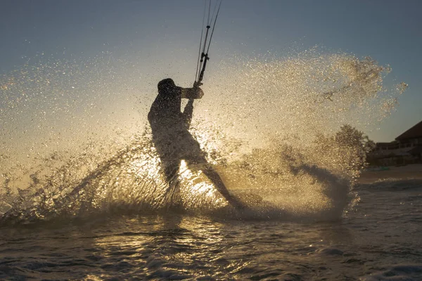 一个风筝冲浪运动员在日落时乘风破浪 — 图库照片