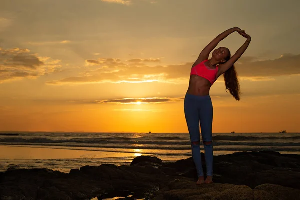 日出日落时美丽海滩上的瑜伽女 — 图库照片