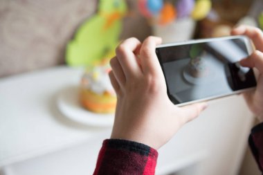 Evde paskalya pastası yapmak, hamur pişirmek, telefonda fotoğraf çeken bir adam.