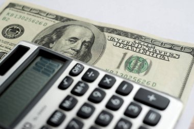 Beyaz arka planda bir hesap makinesi, 100 dolar.