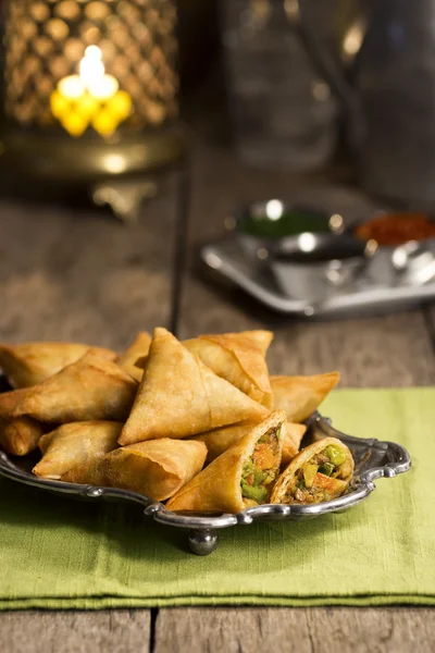 Samosas indias con chutney sobre una mesa en un restaurante —  Fotos de Stock