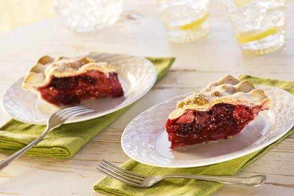 Два ломтика ягодного пирога с напитками — стоковое фото