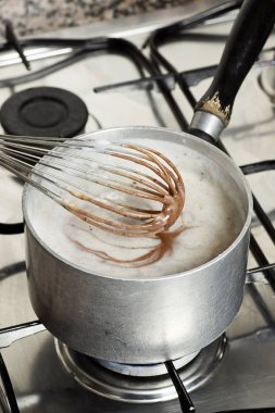 Making Pudding: Whisking the Chocolate Into Thickened Heated Milk clipart