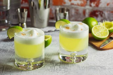 Two Pisco Sour Cocktails with Ingredients on the Bar clipart