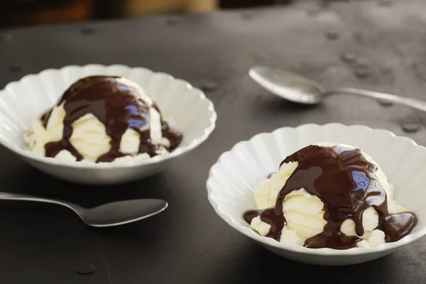 Dos cucharadas de helado de vainilla con salsa de chocolate —  Fotos de Stock