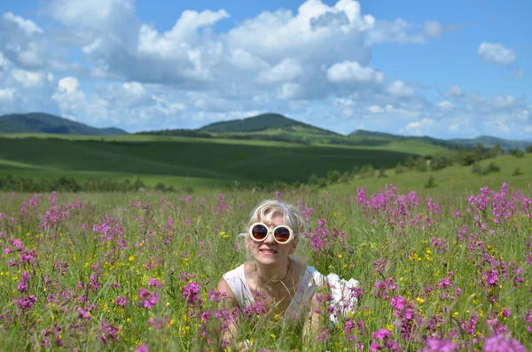 牧草地で横になっているサングラスをかけた女性 — ストック写真