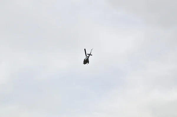 Shot of helicopter from below against grey cloudy sky — Stock Photo, Image