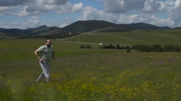 Hombre corriendo sobre un prado — Vídeos de Stock