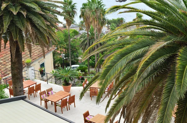 Balkon z palmami i stoły ogrodowe — Zdjęcie stockowe