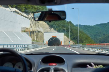 Otoyolda giderken bir tünele yaklaşan araba.