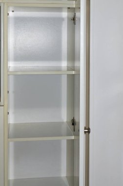 Boş rafları olan bir dolabın kapısını aç.