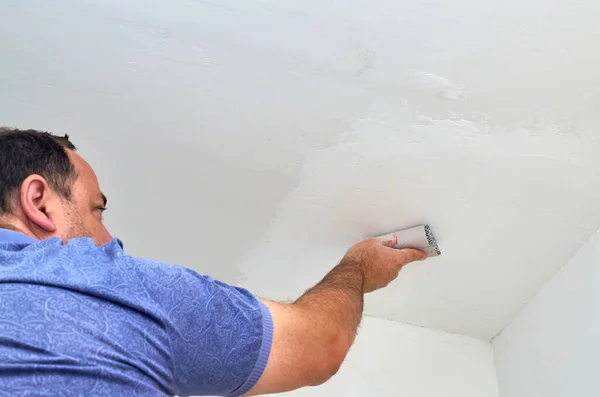 stock image Man holding sandpaper while polishing a ceiling