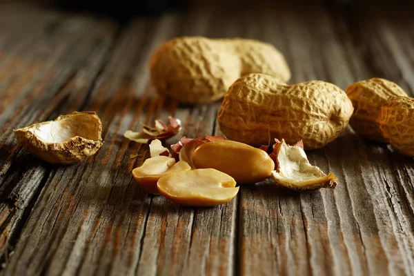 Cacahuètes pelées sur fond de noix entières — Photo