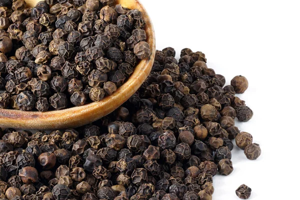 Black pepper in a wooden spoon close up. Stock Image