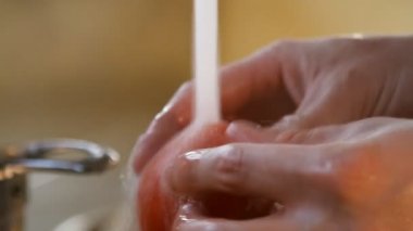 akan suyun altında kırmızı domates erkek ellerinizi yıkayın