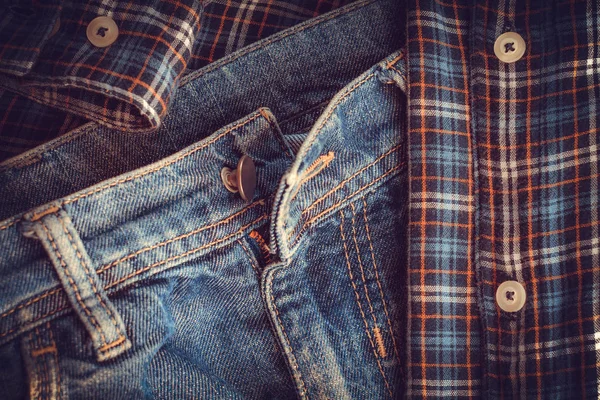 Unbuttoned button on jeans. checkered shirt. still life — Stock Photo, Image