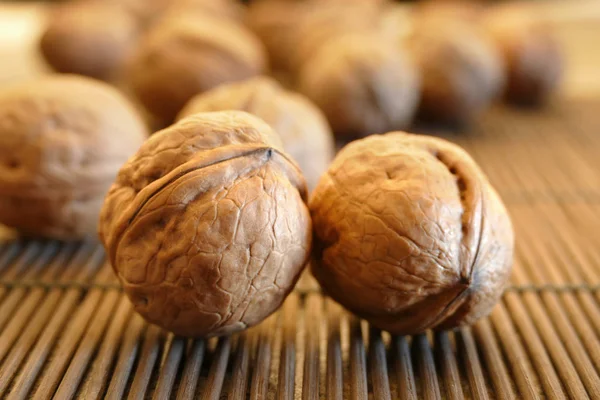 Nueces de cerca. Grupo de nueces una servilleta de bambú — Foto de stock gratis